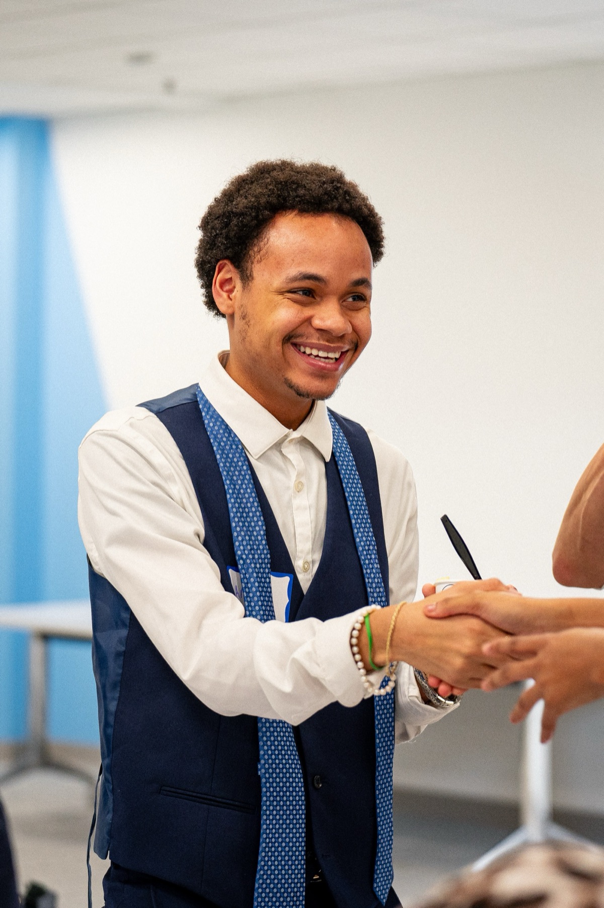 A smiling CareerLabs fellow shaking hands at a Boys & Girls Clubs of Boston networking event